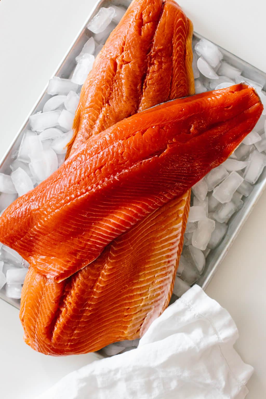 Raw salmon filets on a tray of ice.