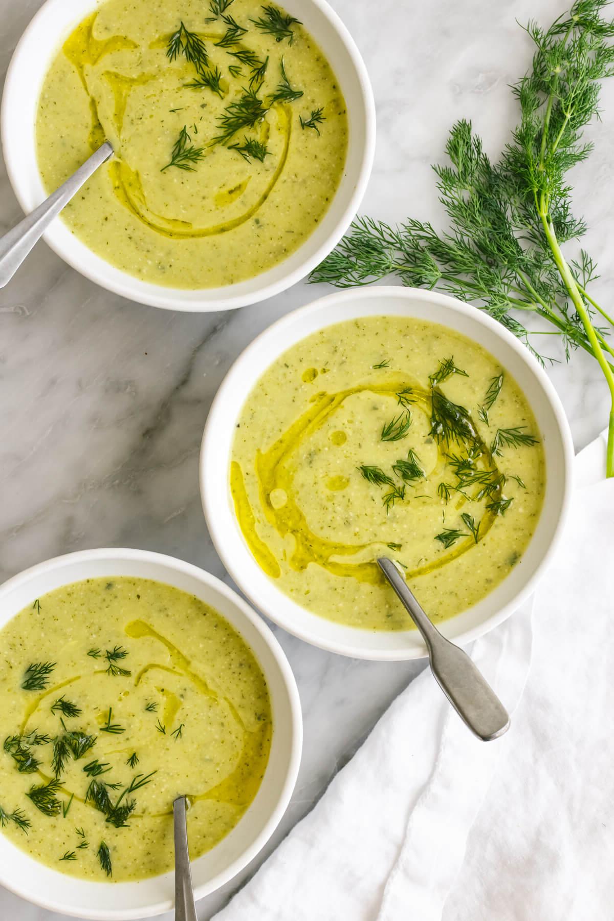 Über 20 beste Zucchini-Rezepte 2 Schalen mit Zucchinisuppe neben Dill.