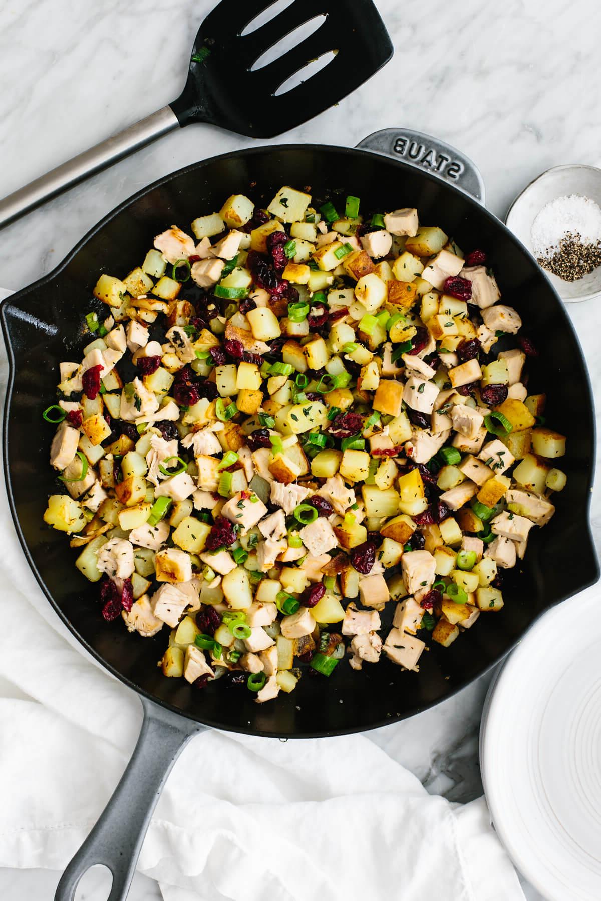 Begeisternde Truthahnreste-Rezepte 2 Truthahn-Cranberry-Hash in einer Pfanne.