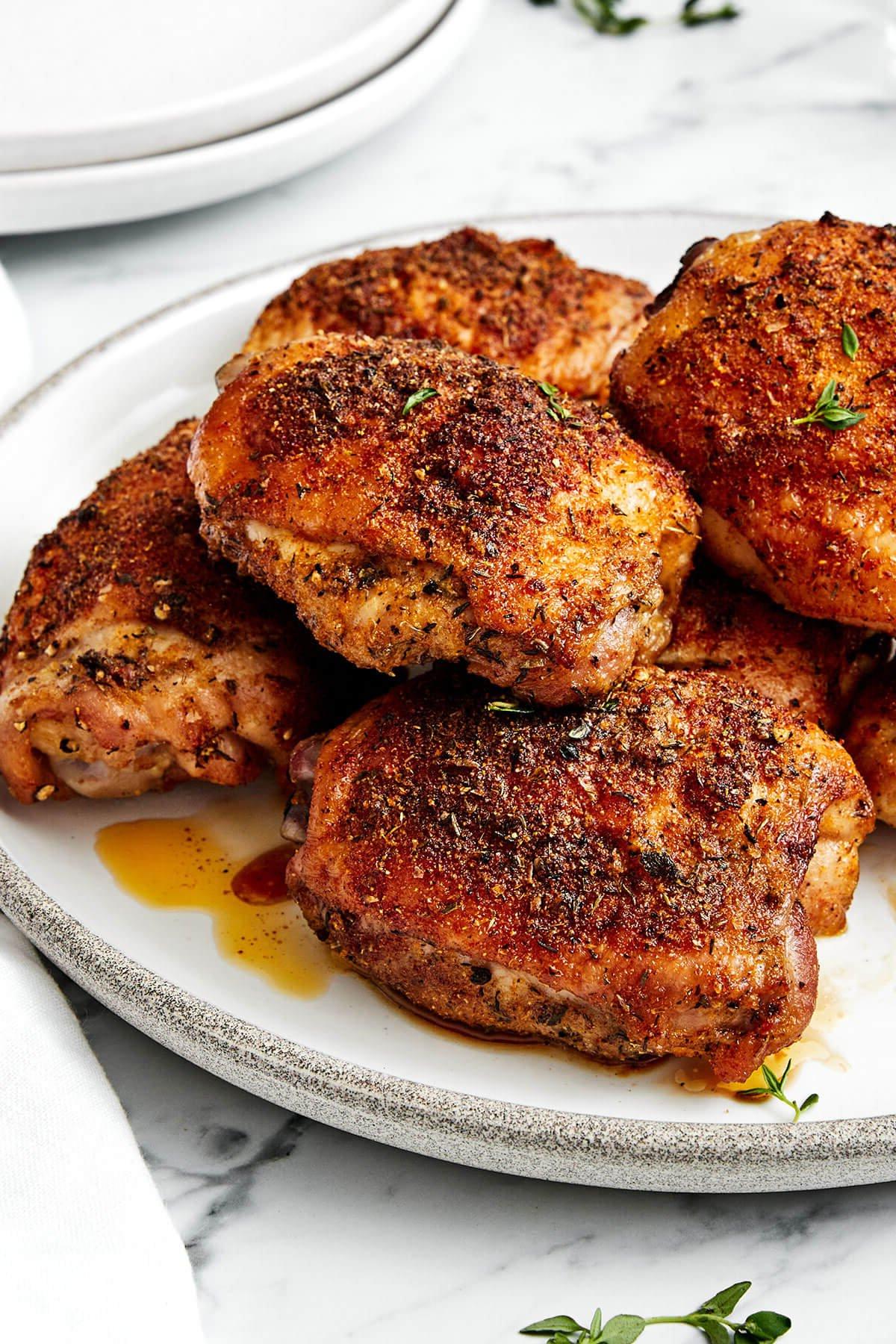 10+ Beste Hähnchenschenkel-Rezepte 11 Knusprig gebackene Hähnchenschenkel auf einem Teller.