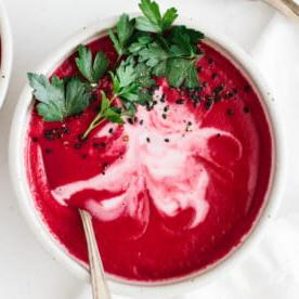 7 gesunde Vitamix-Suppenrezepte für das ganze Jahr 10 Rote Bete Suppe in einer Schüssel, garniert mit Kokoscreme und Petersilie.