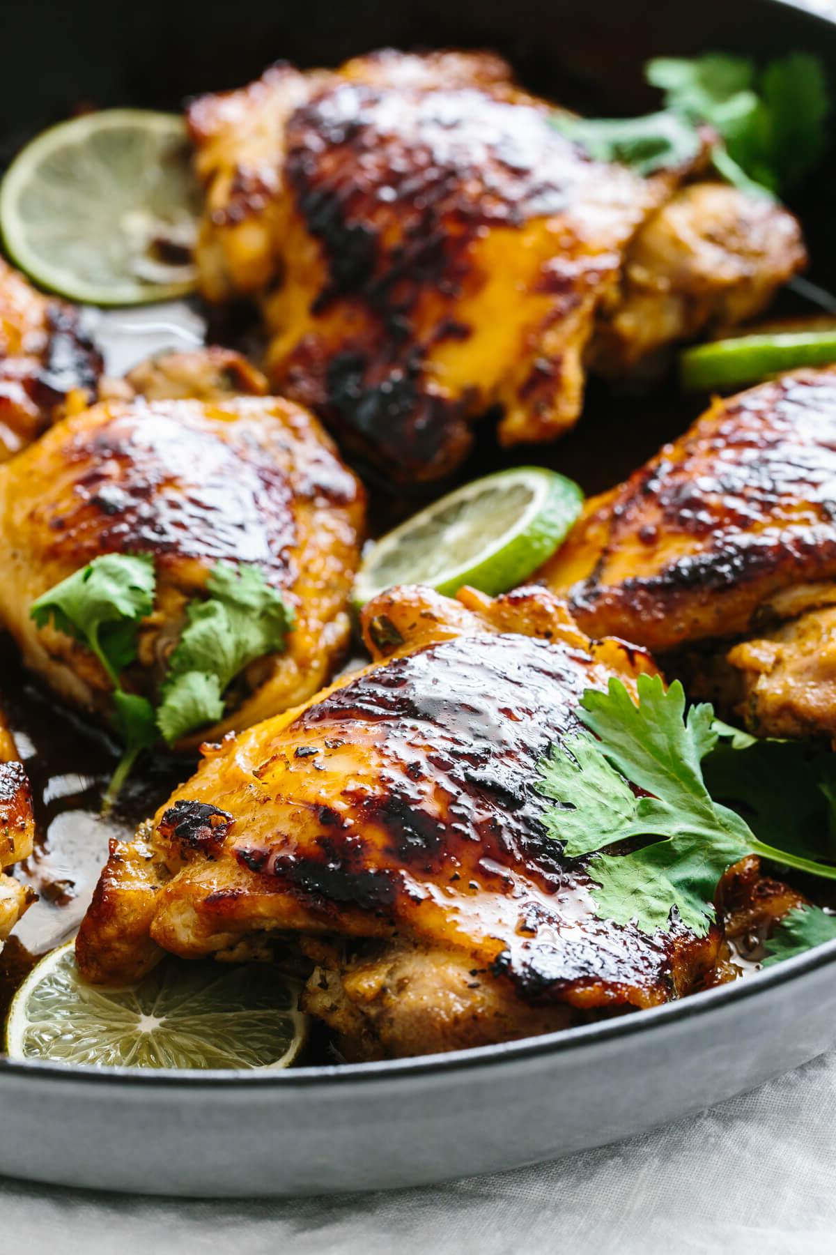 10+ Beste Hähnchenschenkel-Rezepte 12 Nahaufnahme eines Koriander-Limetten-Hähnchenschenkels in einer Pfanne.