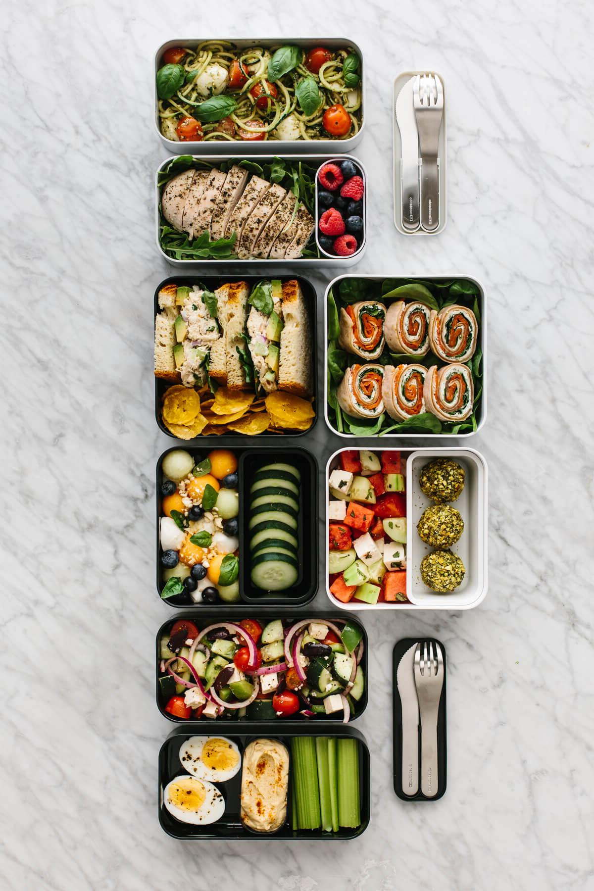 30+ Gesunde Mittagessen-Ideen 12 Mehrere Bento-Box-Mittagessen nebeneinander auf einer Arbeitsplatte angeordnet.