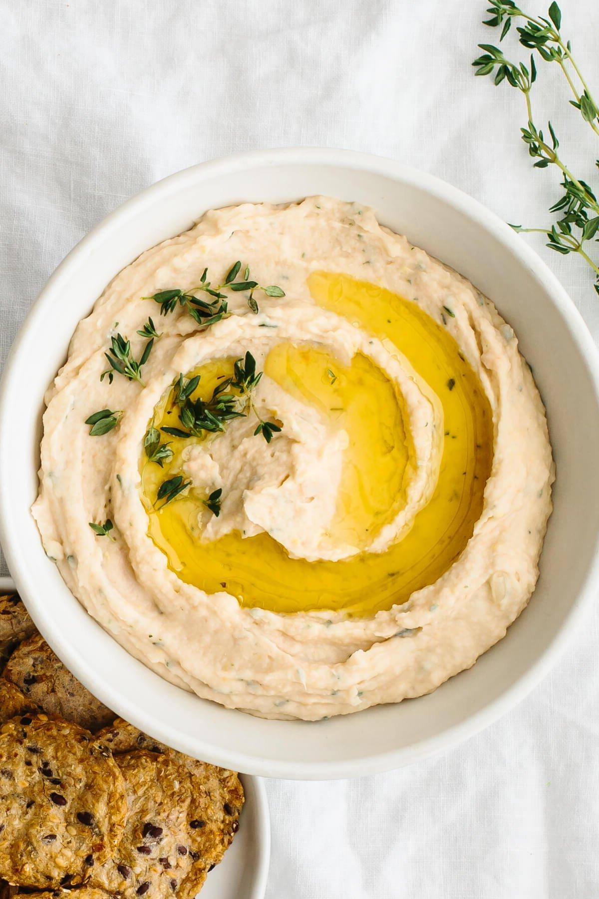 Über 40 Osterrezepte: Frisch, klassisch und einfach 13 Weißbohnendip in einer Schüssel neben Crackern.