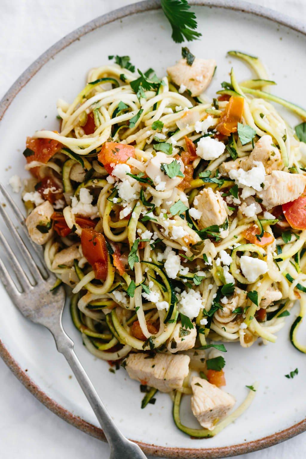 30 gesunde Rezepte in 30 Minuten oder weniger 13 Nahaufnahme von Zucchini-Nudeln mit Hähnchen und Pico de Gallo auf einem weißen Teller.