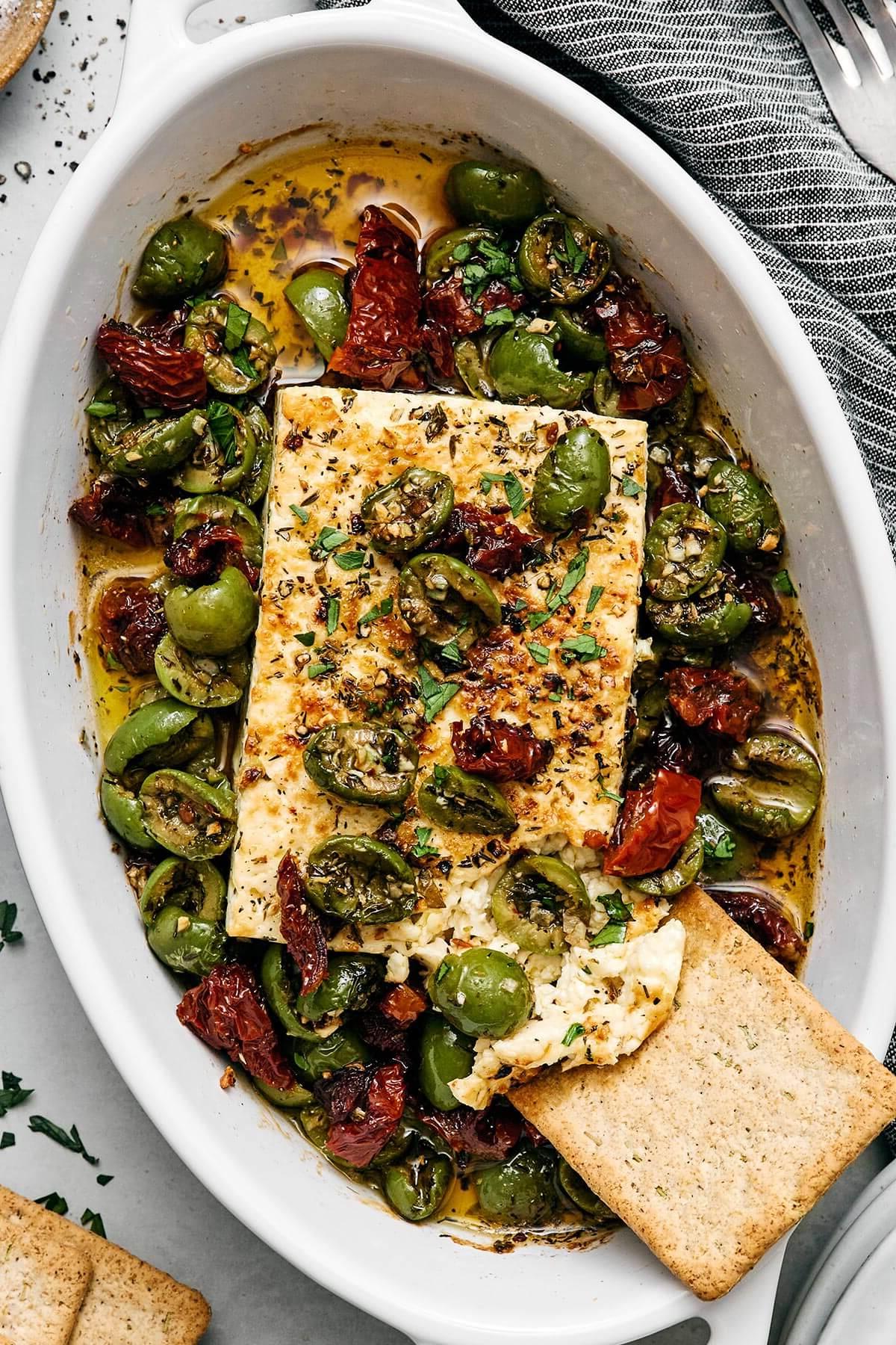 Die 60+ besten Mittelmeer-Diät-Rezepte 13 Mediterraner gebackener Feta mit einem Cracker.