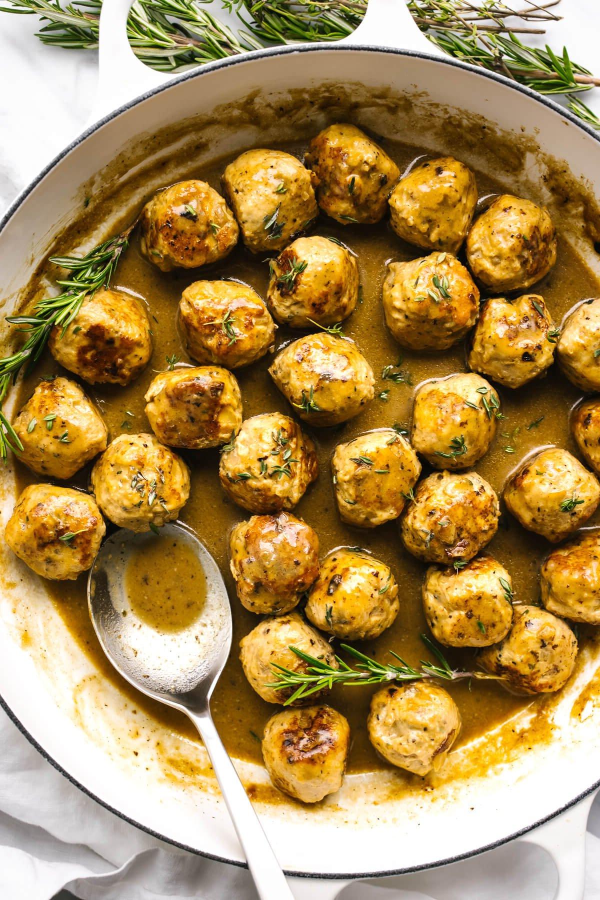 Thanksgiving Menü und Rezepte 9 Truthahn-Hackbällchen in einer Pfanne mit Ahorn-Senf-Sauce und einem Löffel.