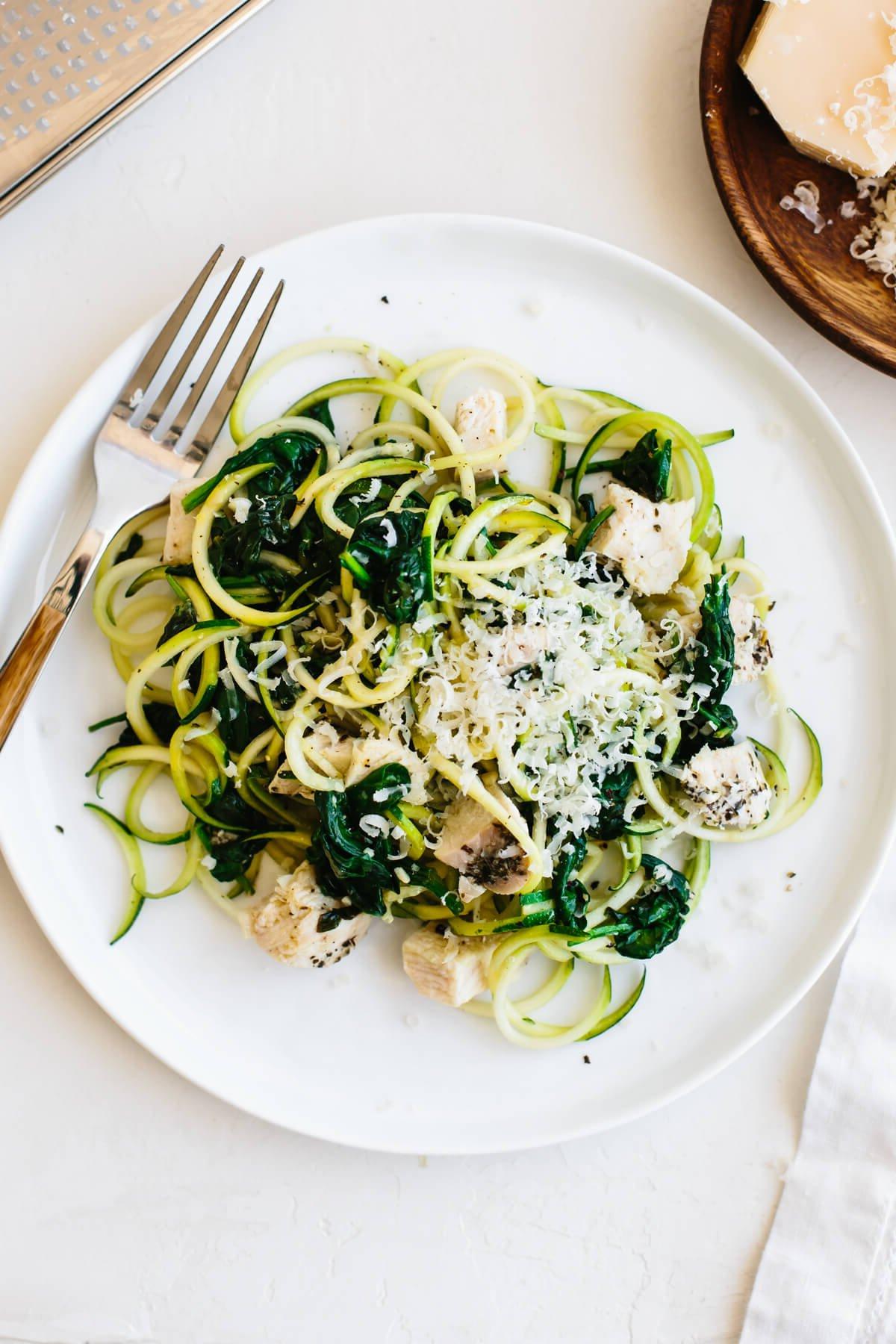 Über 20 beste Zucchini-Rezepte 14 Zucchini-Nudeln mit Hähnchen auf einem Teller mit Gabel.