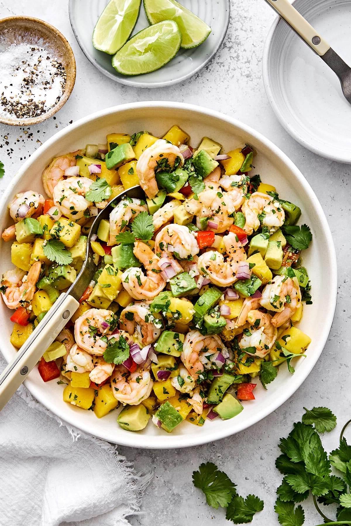 10+ beste Garnelenrezepte 14 Eine Schüssel Mango-Avocado-Garnelensalat.