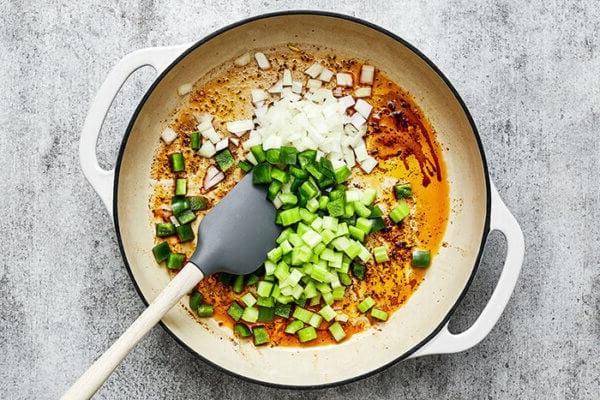 Gemüse für Cajun Hähnchen in einer Pfanne kochen