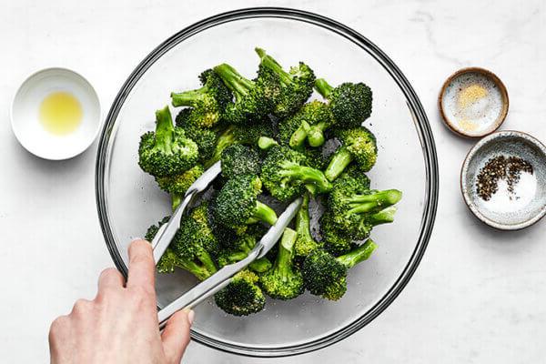 Mixing seasoning with air fryer broccoli