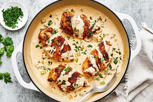 Cremiges Cajun Hähnchen in einer Auflaufform, reichhaltig mit Sauce und Gemüse.