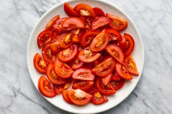 Ein Teller mit geschnittenen Tomaten für einen Avocado-Salat