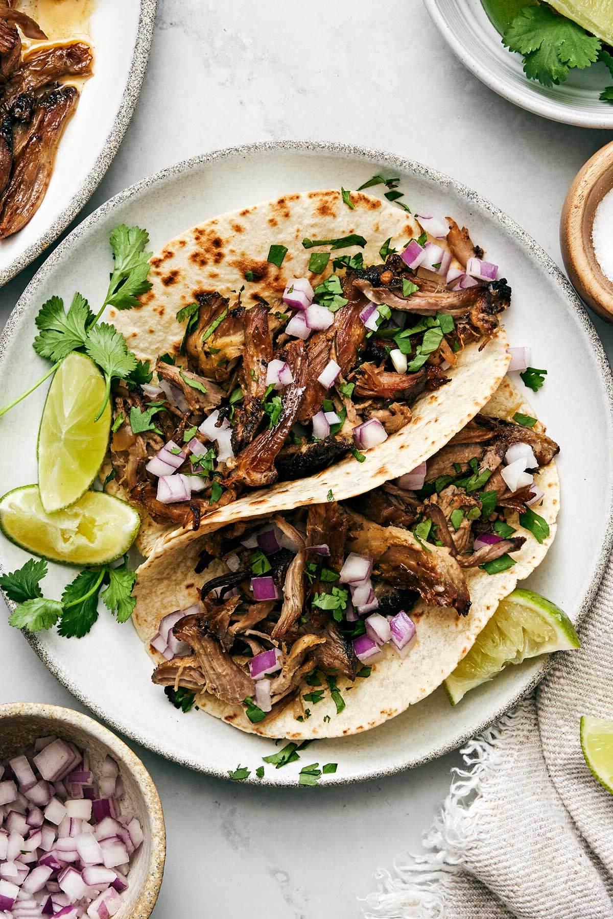 30+ Mexikanische Rezepte – Perfekt für den Cinco de Mayo 17 Carnitas Tacos auf einem Teller.