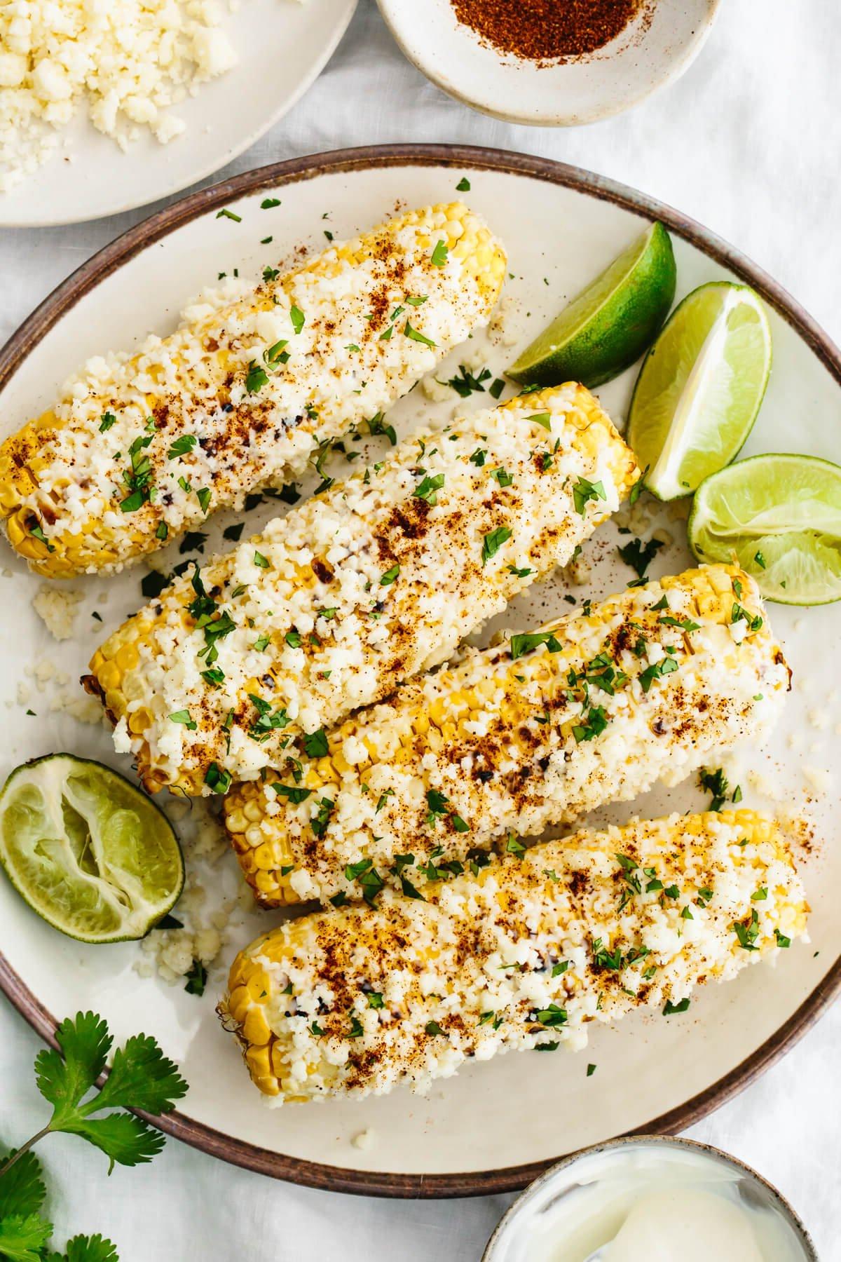 15+ einfache Grillrezepte für den Sommer 18 Elote auf einem Teller mit Limetten