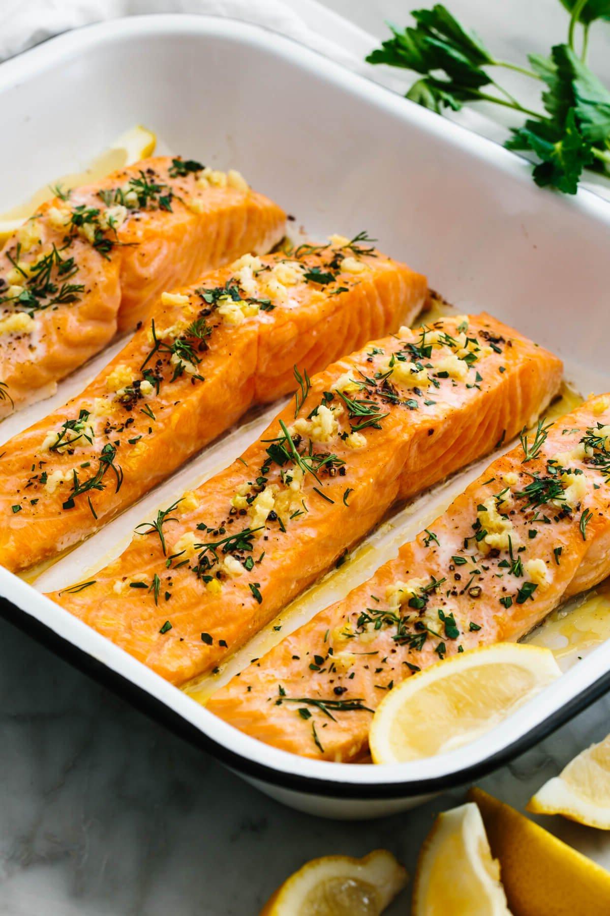 30 gesunde Rezepte in 30 Minuten oder weniger 19 Gebackener Lachs in einer Pfanne neben Zitronenspalten.
