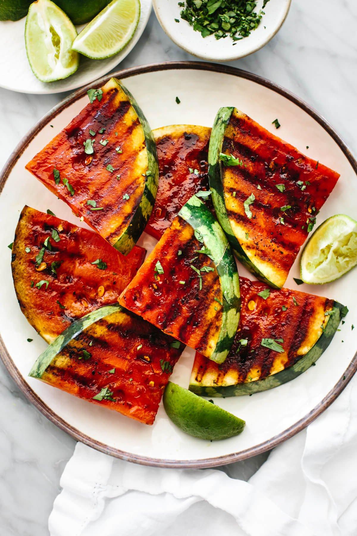 15+ einfache Grillrezepte für den Sommer 20 Gegrillte Wassermelonenstücke auf einem weißen Teller