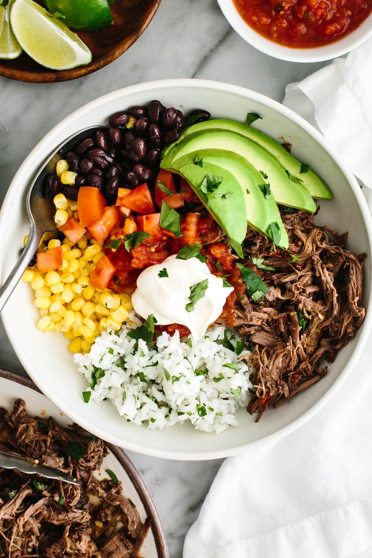 50+ Beste Einfache Abendessen Ideen 20 Rindfleisch-Barbacoa-Burrito-Bowl auf einem Tisch mit Salsa.