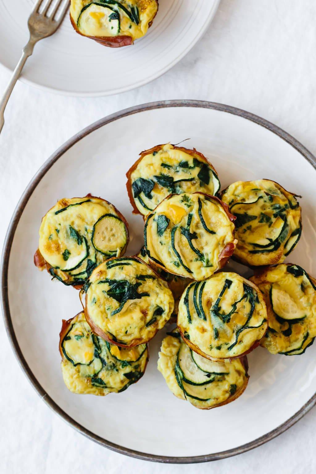 Über 20 beste Zucchini-Rezepte 20 Teller mit Eier-Muffins mit Zucchini und Prosciutto.