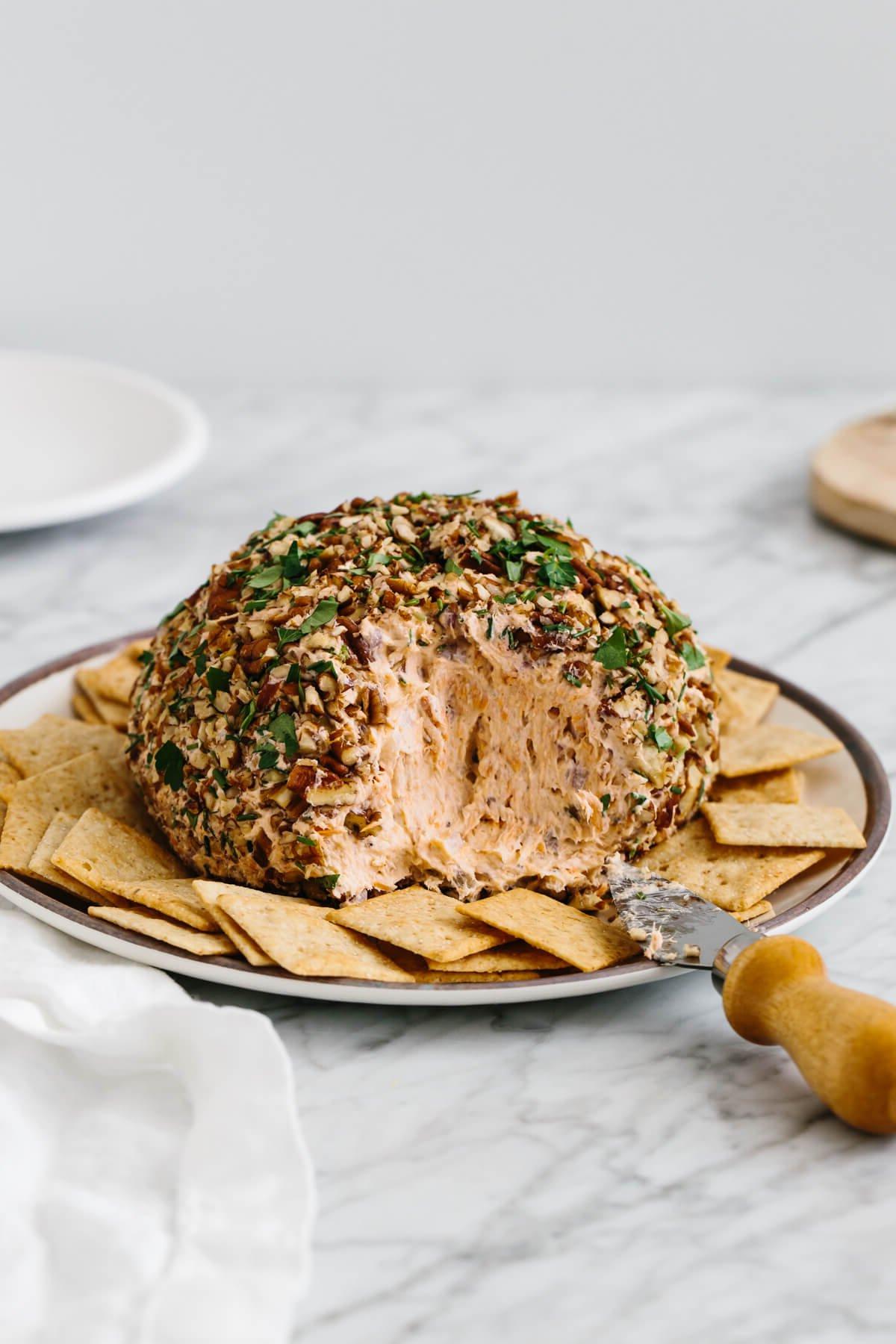 Die 20+ besten Lachsrezepte 21 Lachs-Käse-Ball auf einem Teller, umgeben von Crackern.