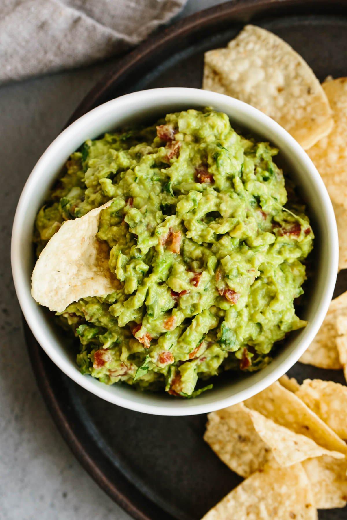 Über 30 festliche Rezepte zum 4. Juli 22 Guacamole in einer Schüssel mit einem Dipping-Chip.