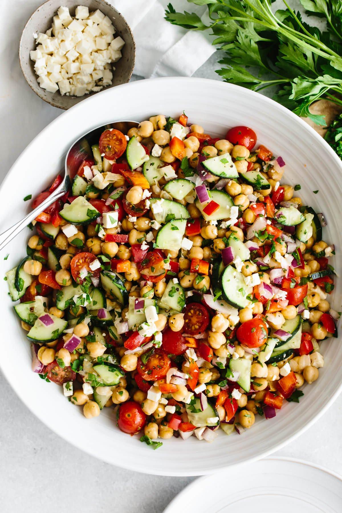 Die 60+ besten Mittelmeer-Diät-Rezepte 23 Mediterraner Kichererbsensalat in einer großen weißen Schüssel auf einem Tisch.