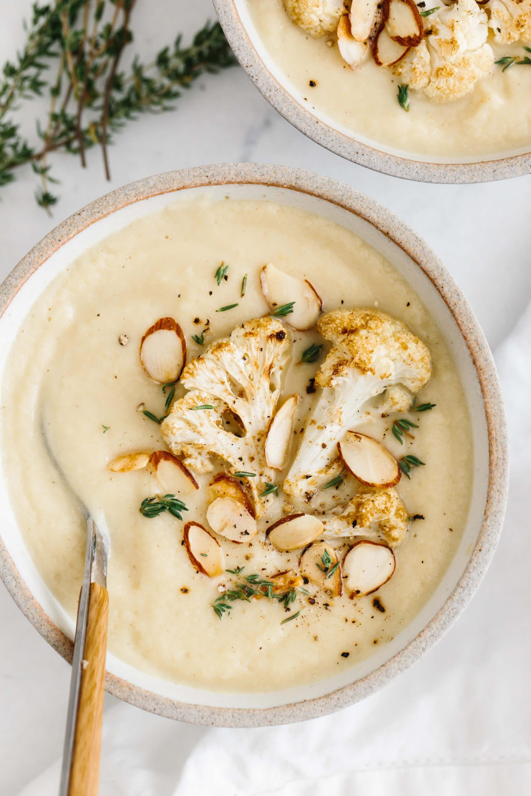 20+ Beste Suppenrezepte für Körper und Seele 27 Geröstete Blumenkohlsuppe in einer Schale, garniert mit Blumenkohl, Mandeln und Thymian.