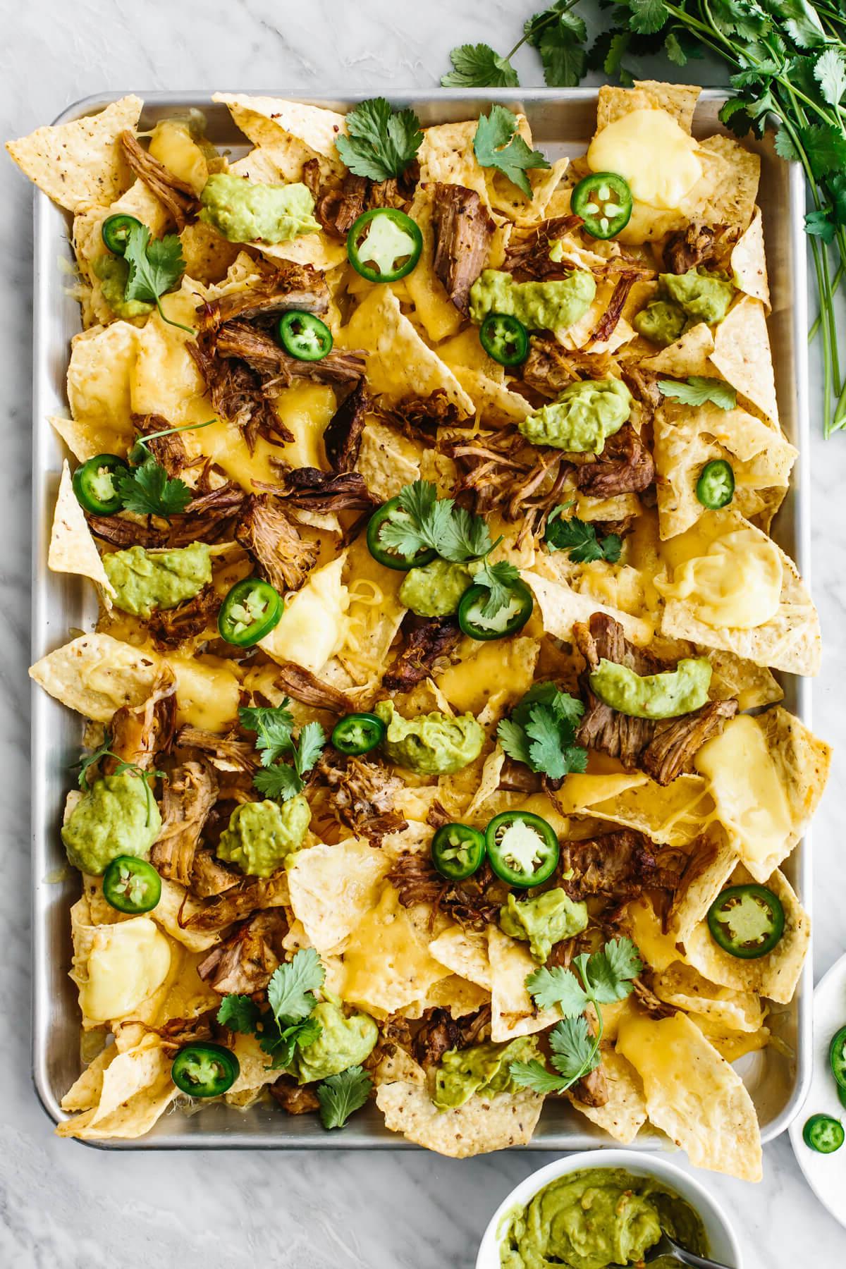 30+ Mexikanische Rezepte – Perfekt für den Cinco de Mayo 27 Ein Tablett mit Carnitas-Nachos auf einem Tisch