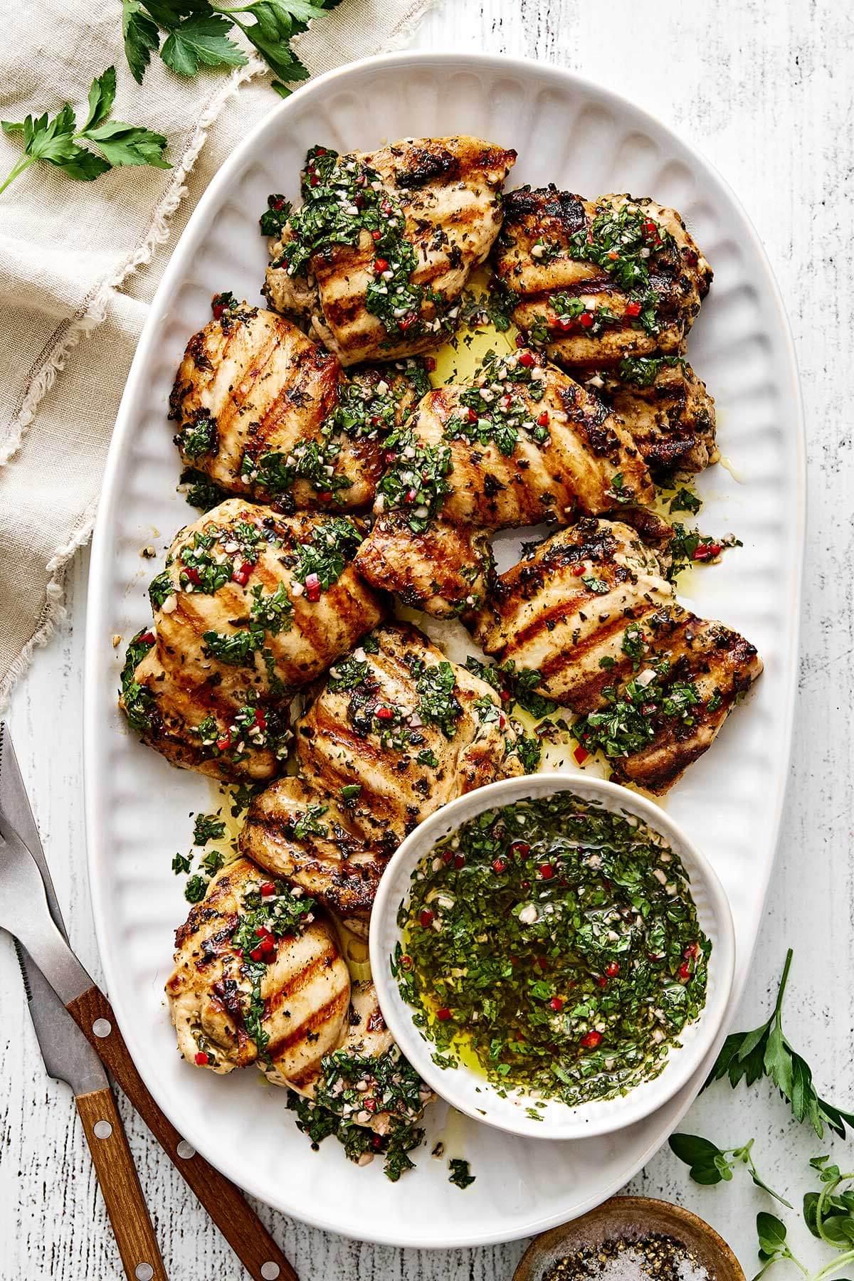 10+ Beste Hähnchenschenkel-Rezepte 4 Ein Teller mit gegrillten Chimichurri-Hähnchenschenkeln.
