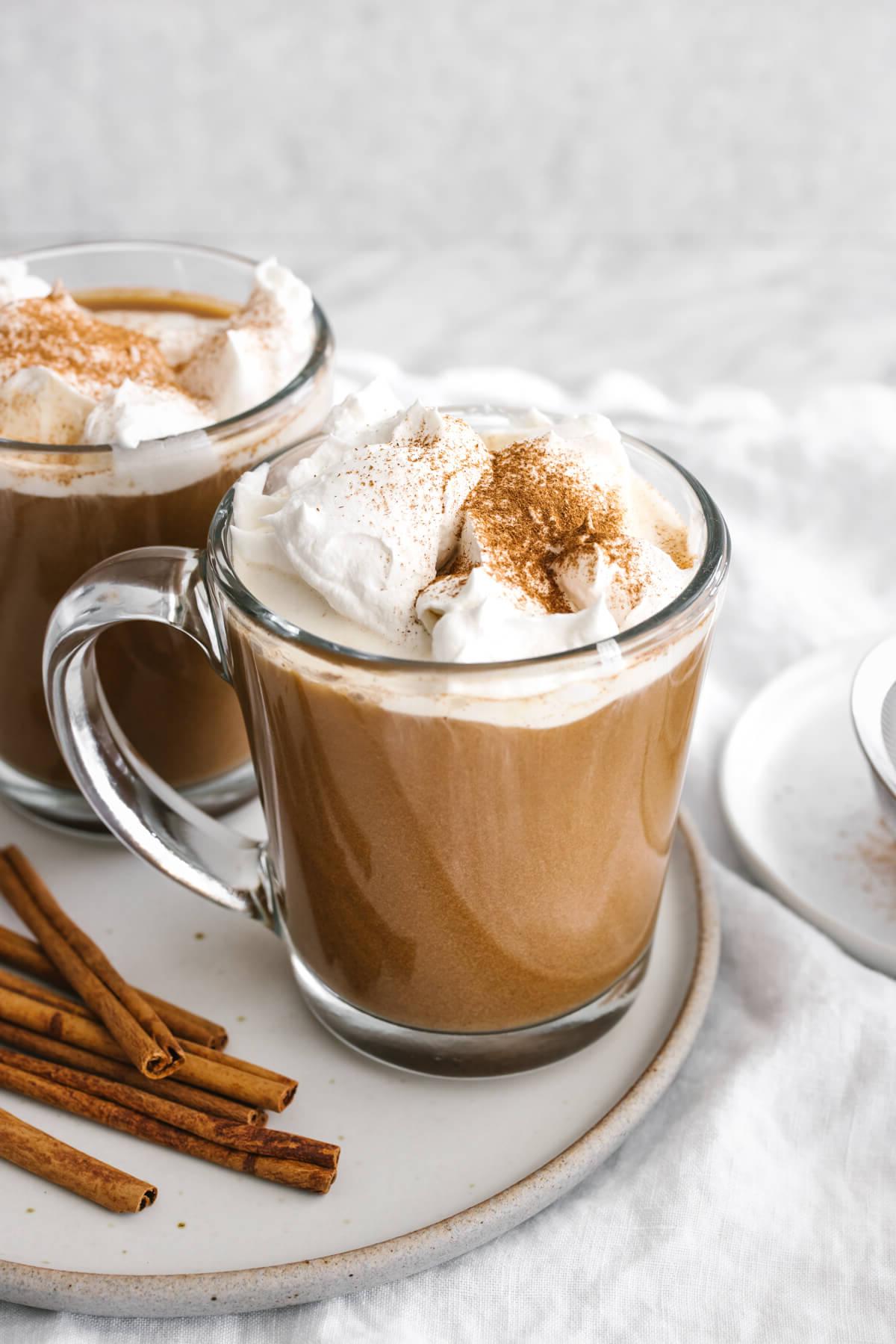 25+ Einzigartige Erntedankfest-Desserts 4 Zwei Tassen Pumpkin Spice Latte auf einem Teller.