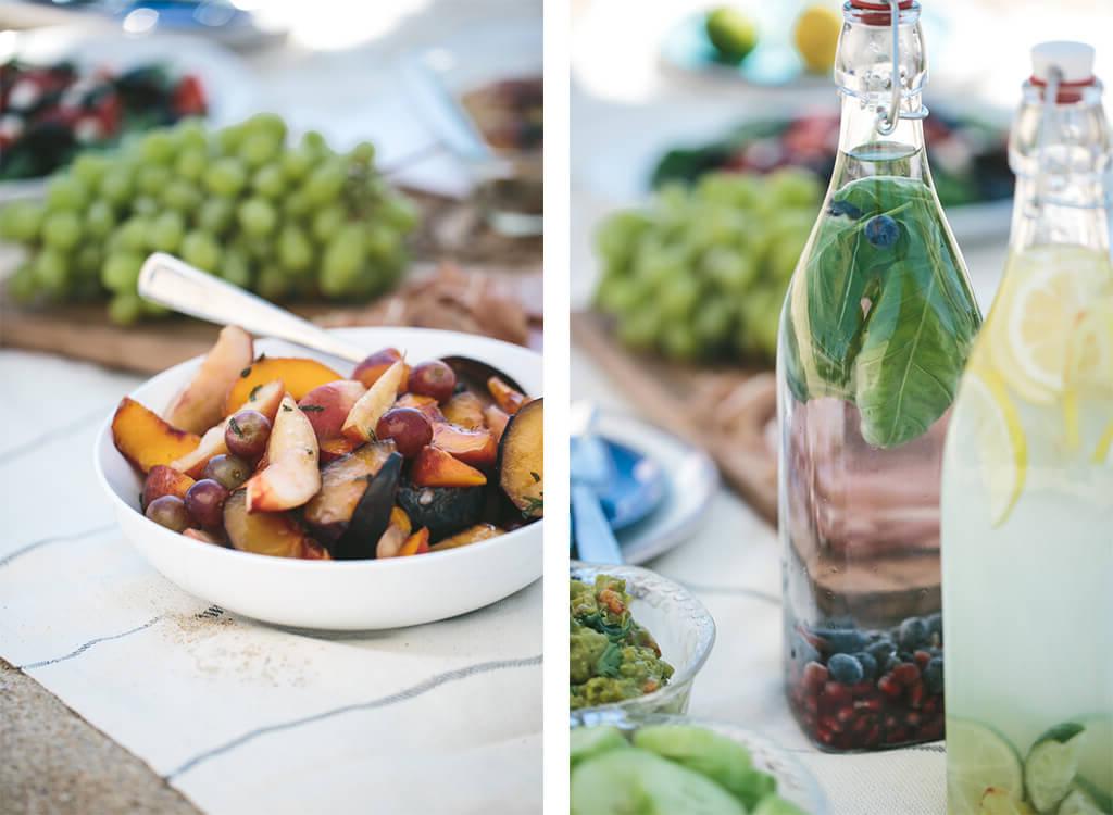 Gesunde Rezepte für den Tag der Arbeit, perfekt für ein Picknick, Grillfest oder eine Party! Zwei Flaschen Infusionswasser und eine Stranddecke mit Picknickessen.