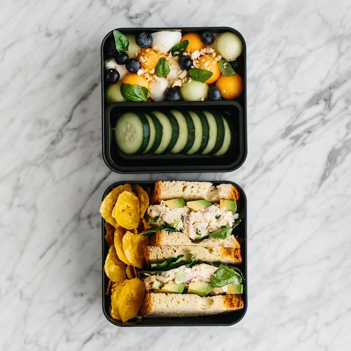 Diese gesunden Bento Lunchbox-Ideen sind perfekt für Arbeit oder Schule! Bento Box gefüllt mit Thunfischsalat-Sandwich, Obstsalat und Chips.