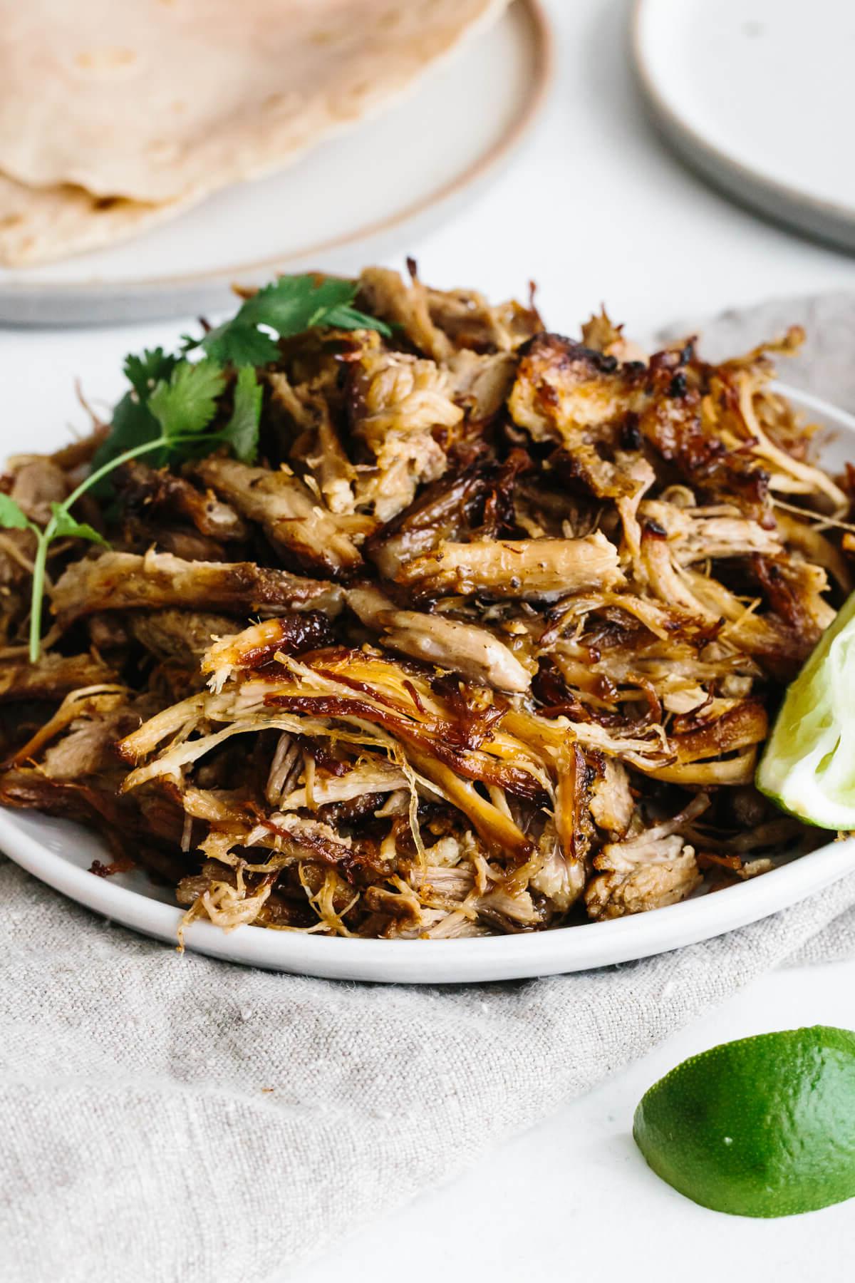 Über 50 einfache Whole30 Abendessen-Rezepte 44 Ein Stapel Carnitas auf einer Servierplatte.