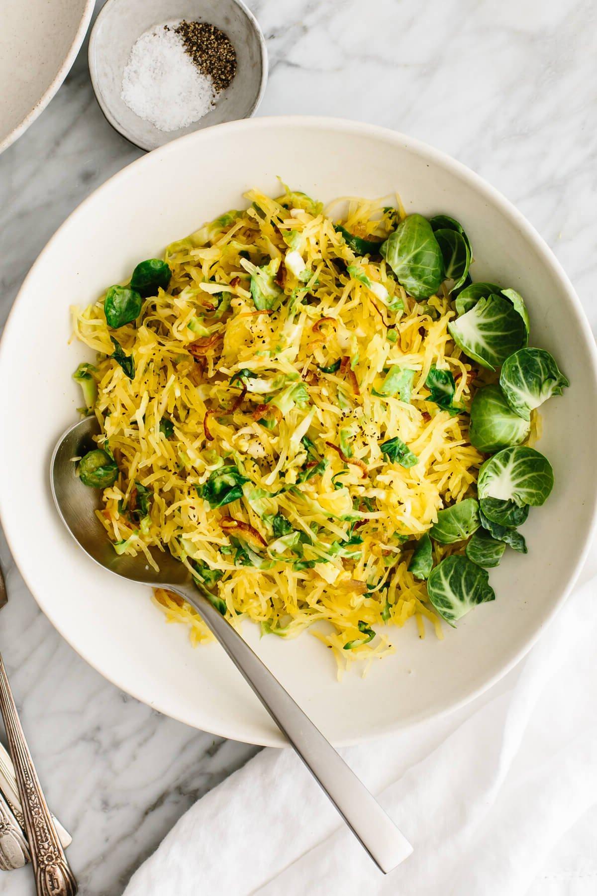 Die 60+ besten Mittelmeer-Diät-Rezepte 45 Spaghettikürbis, Rosenkohl und knusprige Schalotten als Beilage in einer Schüssel.