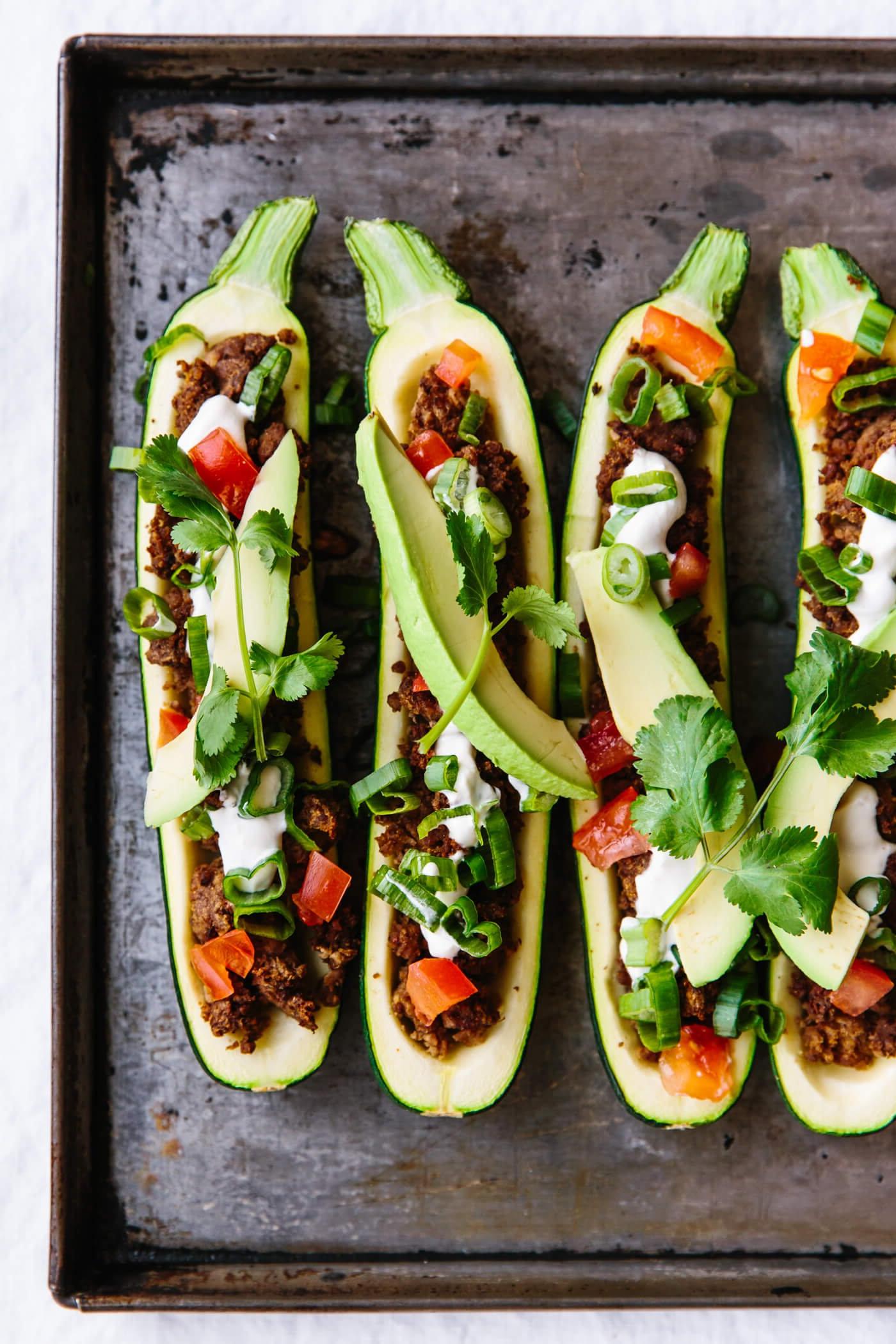 Über 50 einfache Whole30 Abendessen-Rezepte 48 Taco gefüllte Zucchini-Boote auf einem Backblech.