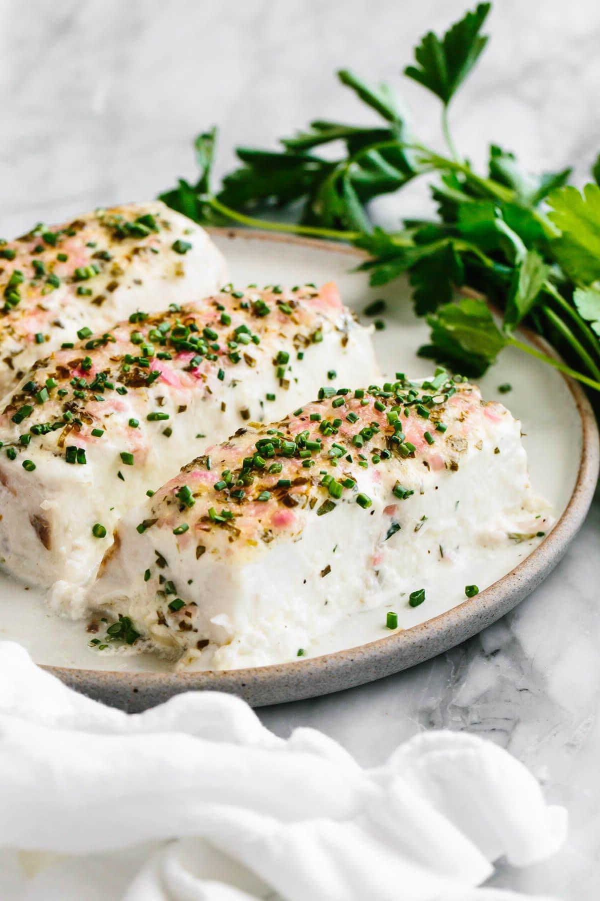 Über 40 Osterrezepte: Frisch, klassisch und einfach 49 Gebackener Heilbutt mit Kräuter-Mayonnaise-Kruste auf einem Teller.