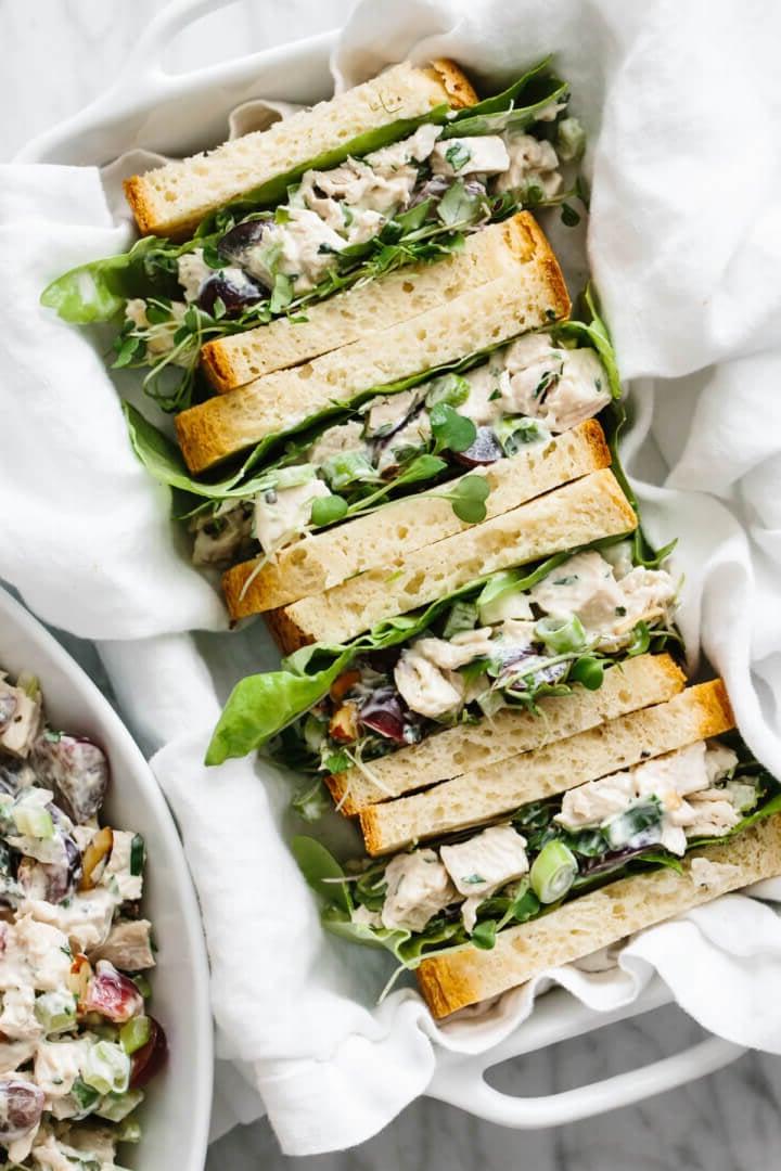 30+ Gesunde Mittagessen-Ideen 6 Hähnchensalat-Sandwiches in Hälften geschnitten auf einem Serviertablett.