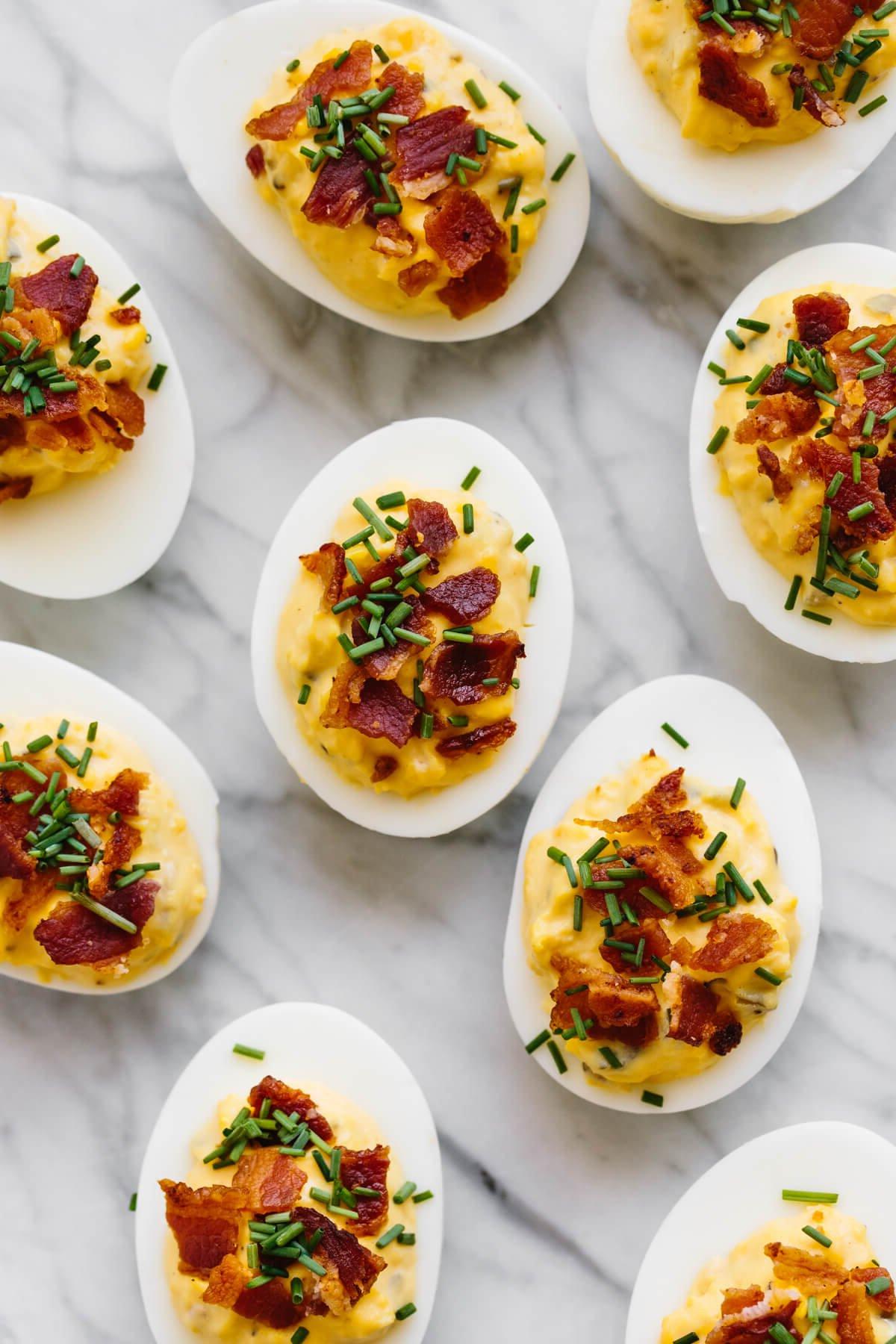 Über 40 Osterrezepte: Frisch, klassisch und einfach 6 Mehrere gefüllte Eier mit Speck auf einer Marmorplatte.