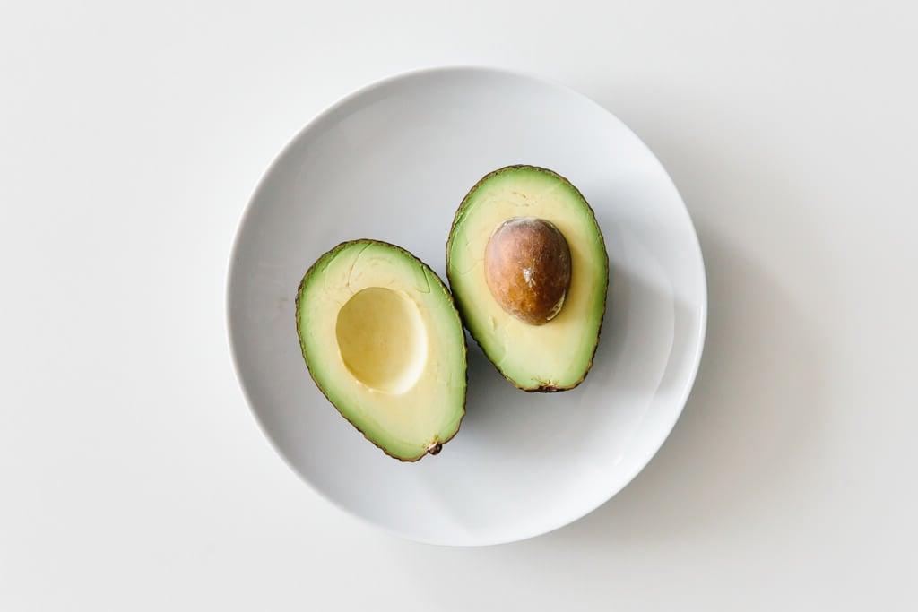 Aufgeschnittene Avocado auf einem weißen Tisch.
