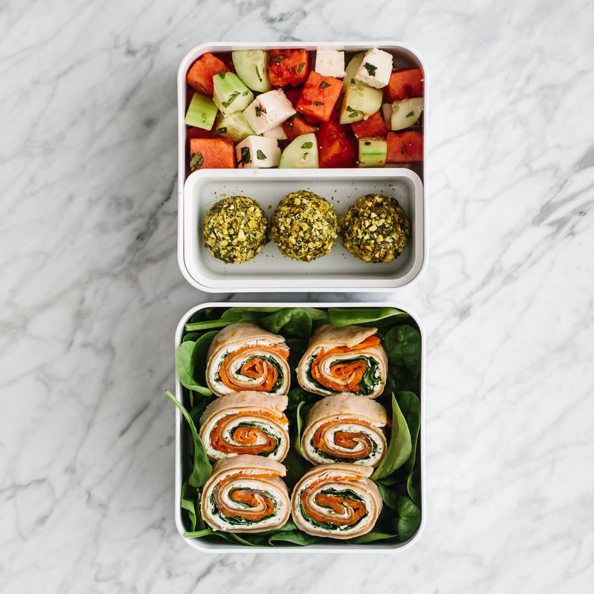 Diese gesunden Bento Lunchbox-Ideen sind perfekt für Arbeit oder Schule! Bento Box gefüllt mit Lachs-Pinwheels, Energiebällchen und Obstsalat.