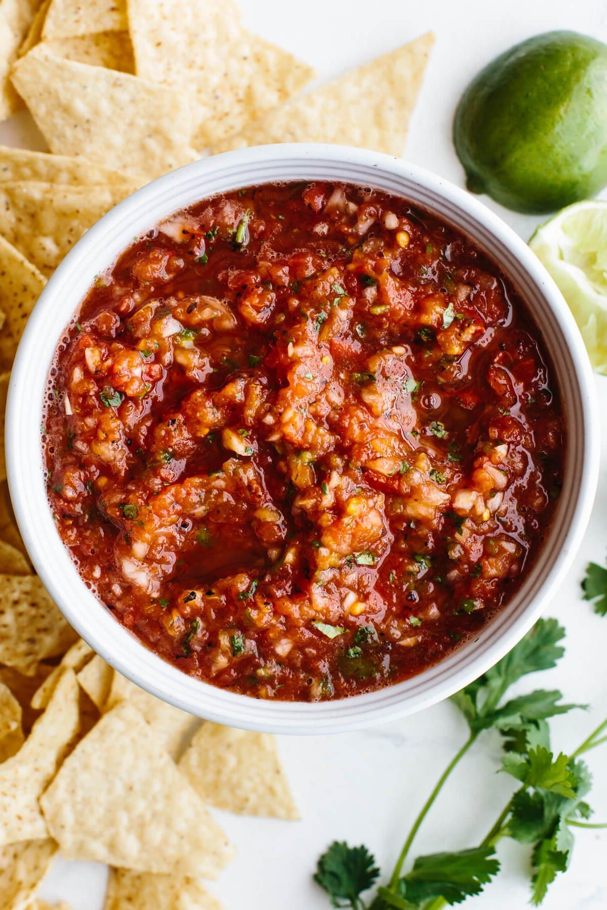 30+ Mexikanische Rezepte – Perfekt für den Cinco de Mayo 6 Salsa-Rezept in einer Schüssel, umgeben von Chips, Limetten und Koriander.