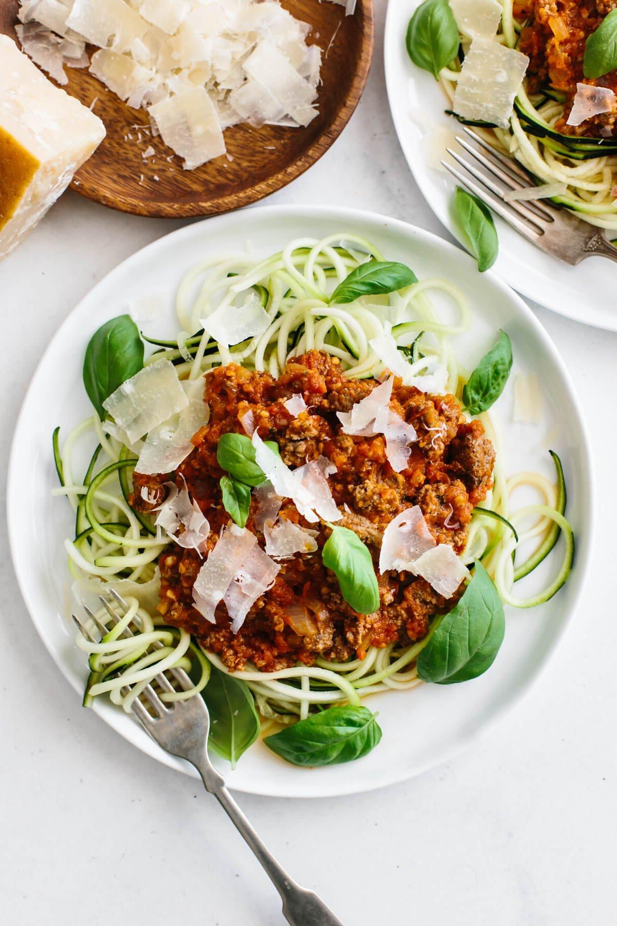 Über 50 einfache Whole30 Abendessen-Rezepte 52 Ein Teller Zucchini-Nudeln mit Bolognese-Sauce, frischem Parmesan und Basilikum.