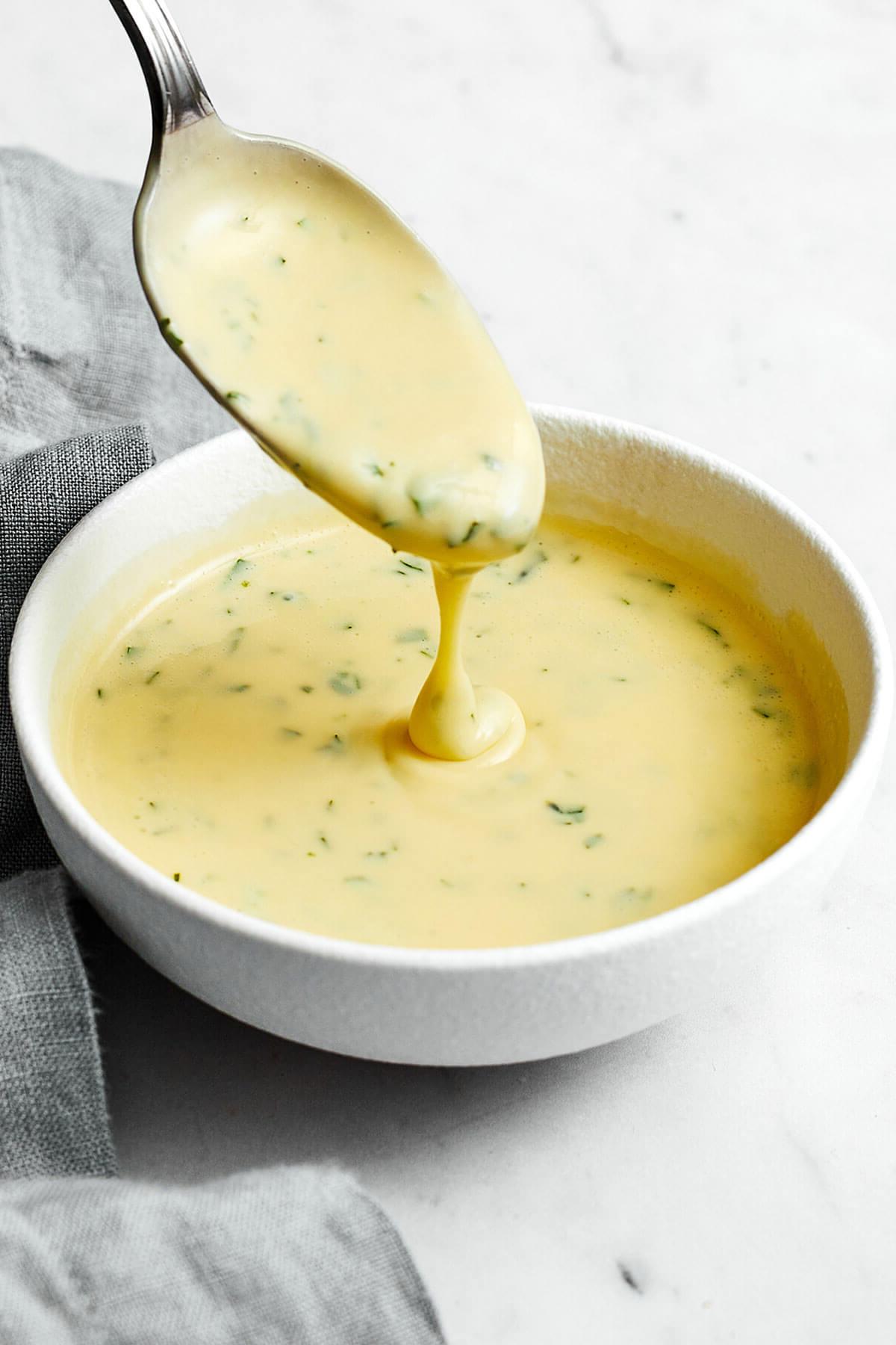 Top 10 Rezepte 2023 7 Béarnaise-Sauce in einer Schüssel mit einem Löffel zum Servieren bereit