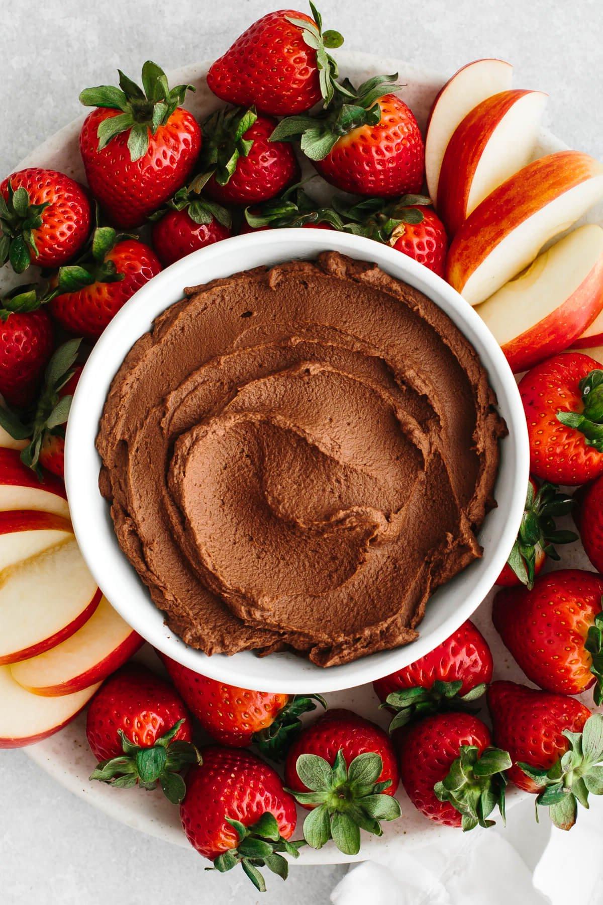 15+ Beste Kichererbsenrezepte 7 Schokoladen-Hummus in einer Schüssel auf einer Platte mit Früchten.