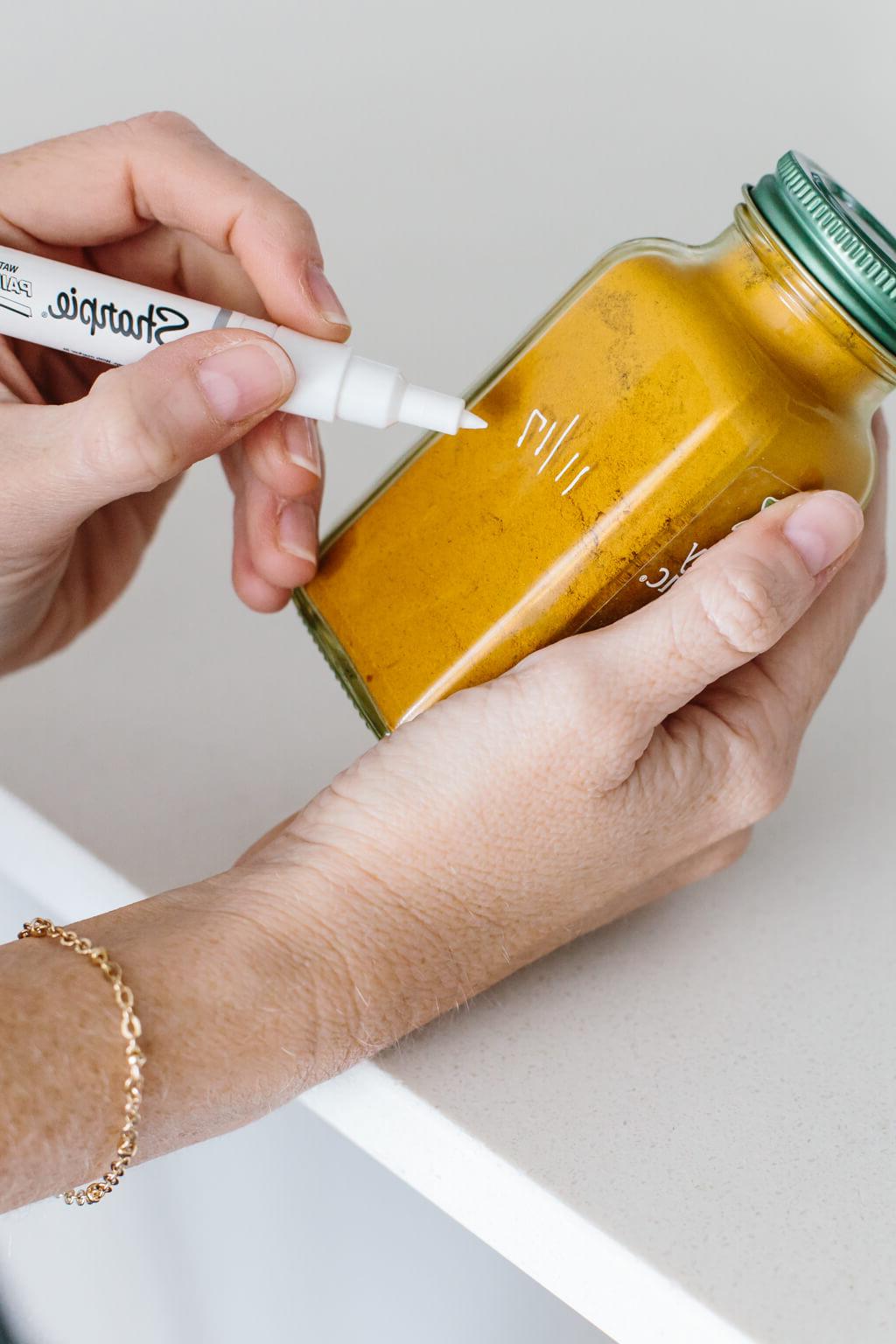 Handbeschriftetes Simply Organic Kreuzkümmelglas in der Gewürzschublade, mit deutlich sichtbarem Öffnungsdatum zur Überprüfung der Frische. #Gewürzhaltbarkeit #Küchenorganisation #FrischeGewürze