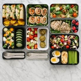 Bento-Box-Mittagessen-Ideen 2 Mehrere Bento Boxen auf einem Tisch mit verschiedenen Mittagsrezepten und Zutaten.