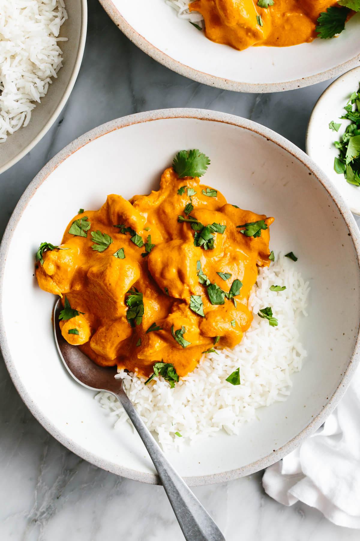 10+ Beste Hähnchenschenkel-Rezepte 8 Butterhähnchen mit Reis in einer Schüssel.