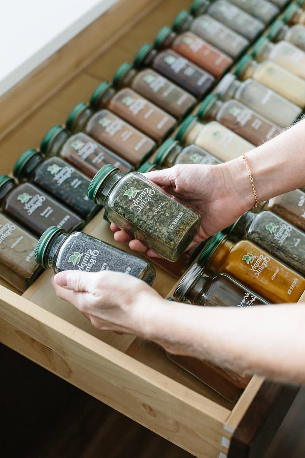 Eine perfekt organisierte Gewürzschublade, die eine Vielzahl von Simply Organic Gewürzgläsern zeigt, ordentlich in gestuften Einsätzen arrangiert, bereit für den Einsatz in der gesunden Küche. #Gewürzsortiment #Kochinspiration #GesundeKüche