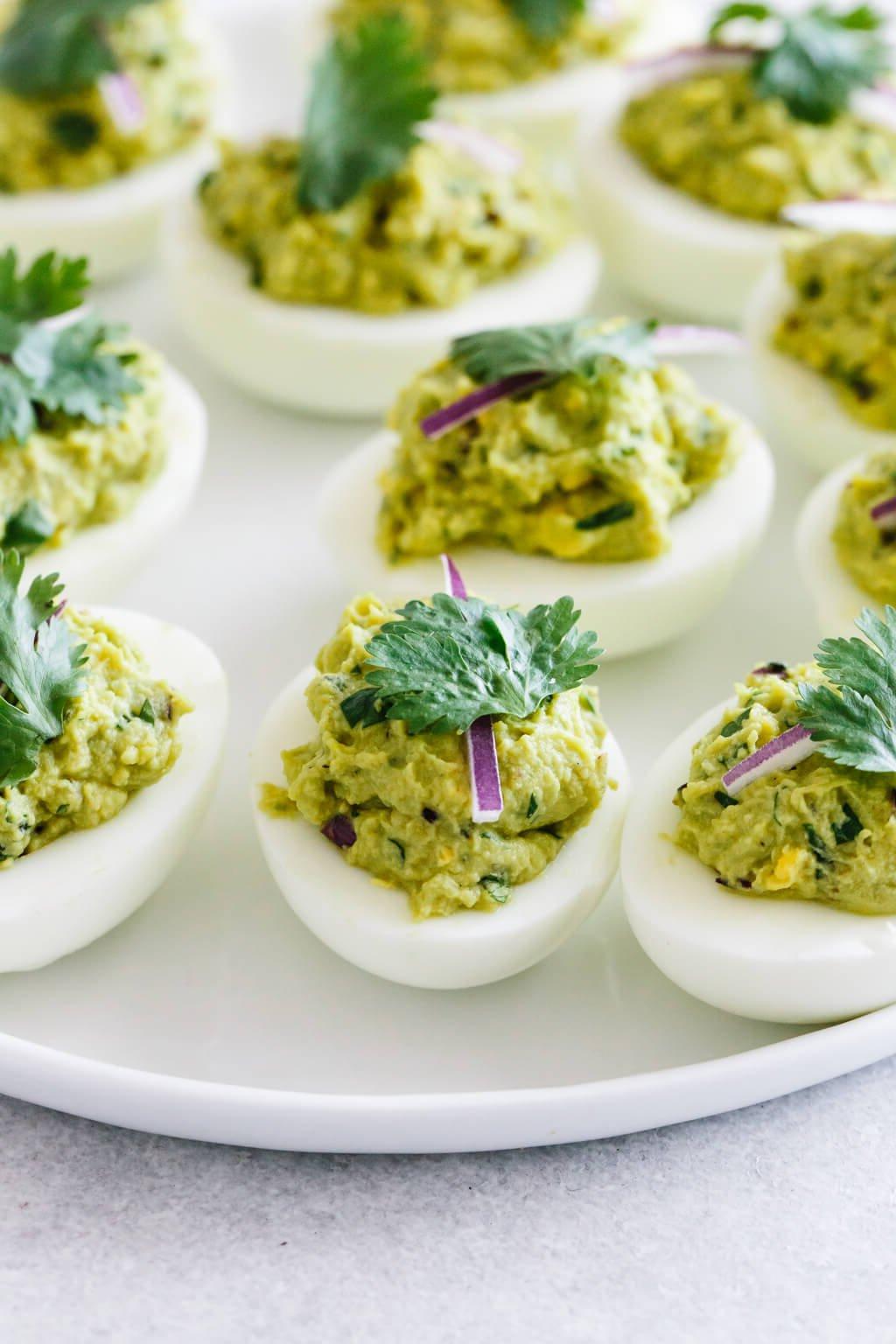 Über 40 Osterrezepte: Frisch, klassisch und einfach 8 Mehrere Avocado-gefüllte Eier auf einem weißen Teller.