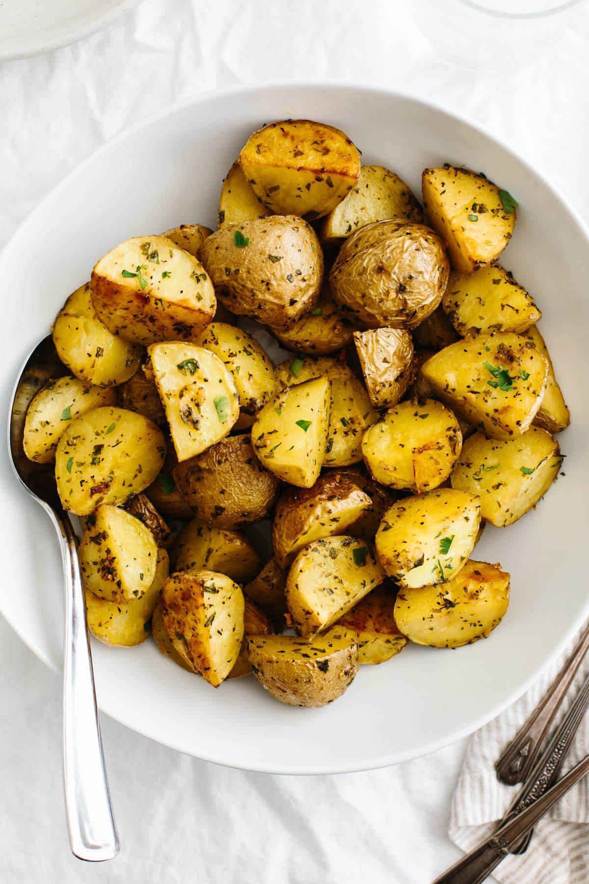 Knoblauch-Kräuter-Bratkartoffeln in einer weißen Servierschale.